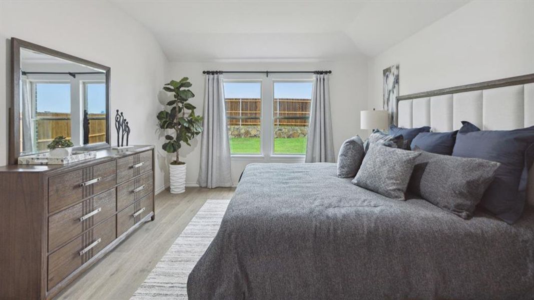 Bedroom with lofted ceiling and light wood-style flooring Bedroom with lofted ceiling and light wood-style flooring