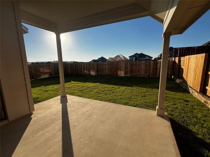 The property features a covered patio with a concrete surface, providing a shaded outdoor living space
