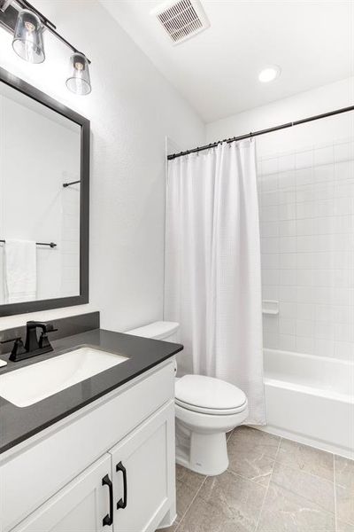 Full bathroom for the two secondary bedrooms located off of the foyer.