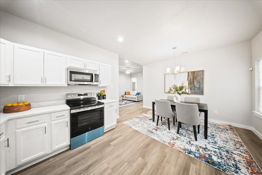 Kitchen featuring stainless steel appliances, white cabinets, light wood-style floors, and recessed lighting Kitchen featuring stainless steel appliances, white cabinets, light wood-style floors, and recessed lighting