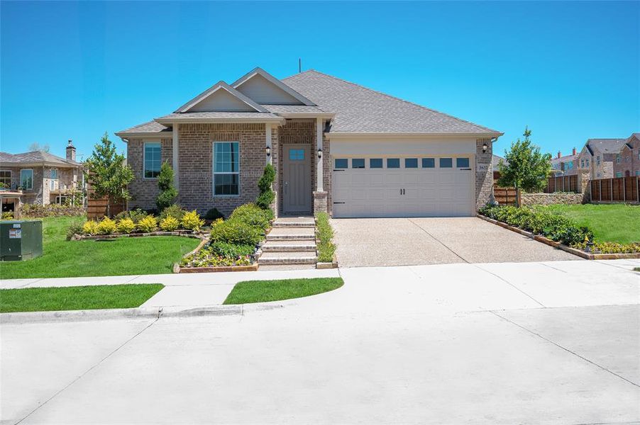 View of front of home with a garage and a front yard