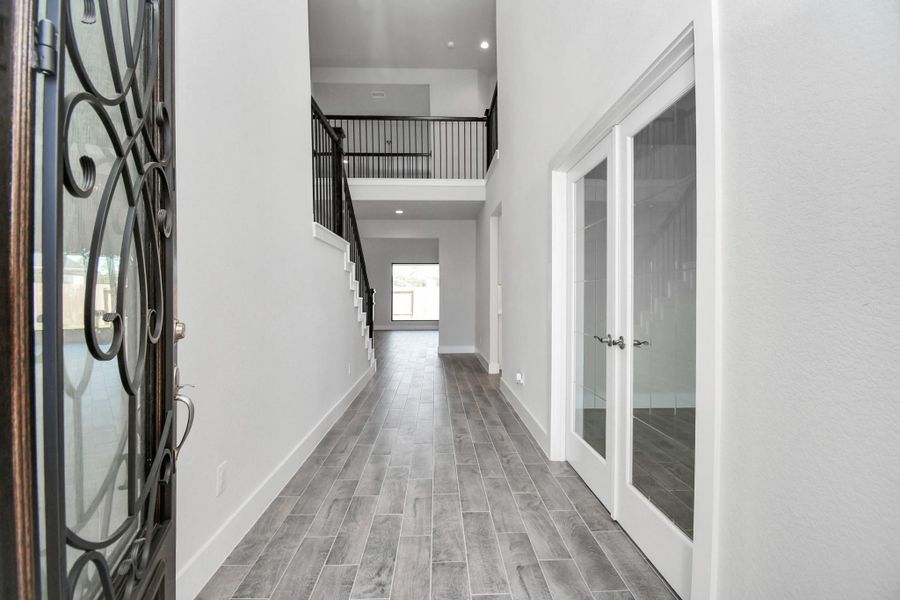 As you step into the threshold of this luxurious home, you'll soon be welcomed by an elegant glass door. Inside, soaring ceilings amplify the spaciousness, while the refined wood-look tile flooring and oversized baseboards exude sophistication and charm. As you step into the threshold of this luxurious home, you'll soon be welcomed by an elegant glass door. Inside, soaring ceilings amplify the spaciousness, while the refined wood-look tile flooring and oversized baseboards exude sophistication and charm.