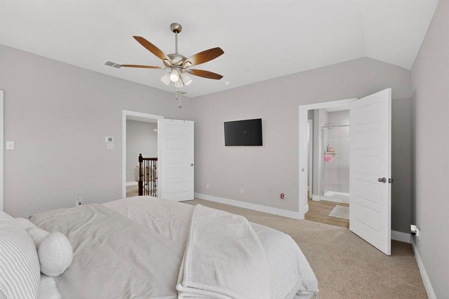 Bedroom featuring a ceiling fan with light fixture, neutral wall colors, and carpeted flooring