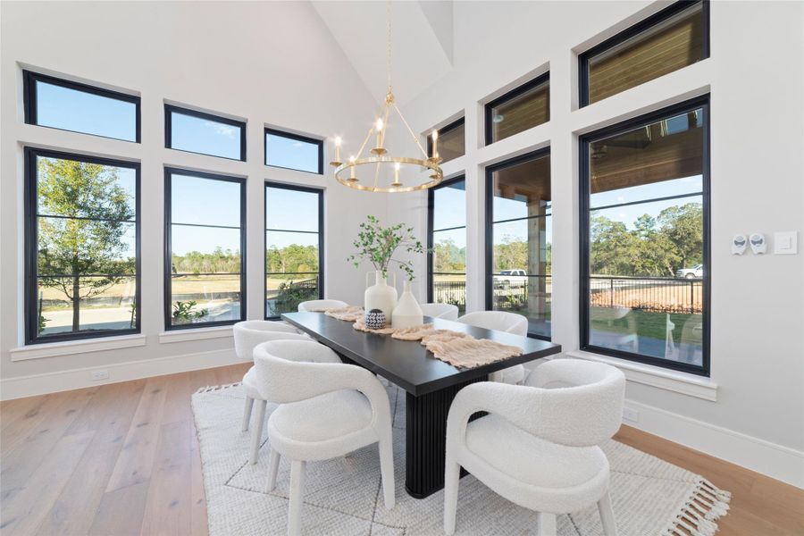 The open concept dining room is surrounded by beautiful windows with scenic outdoor views.
