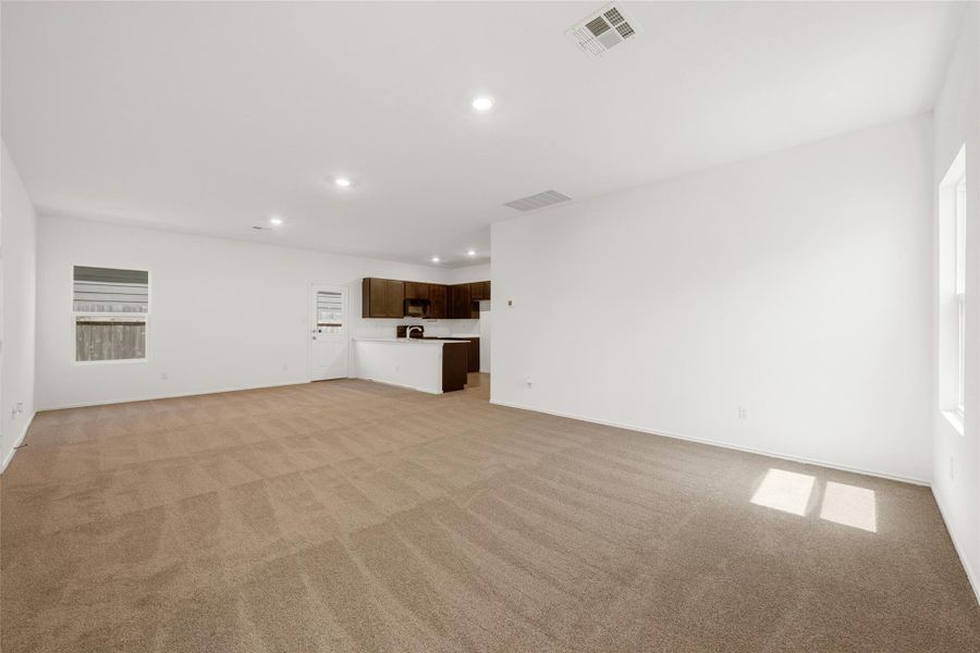 Unfurnished living room featuring recessed lighting and light carpet Unfurnished living room featuring recessed lighting and light carpet