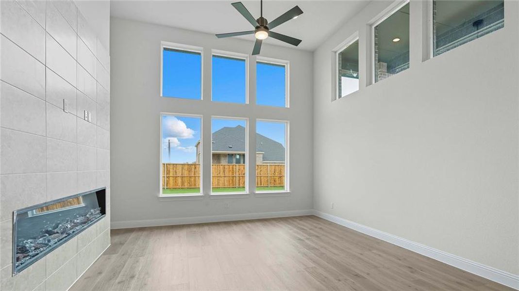 Two-story living area featuring a tiled fireplace with a linear insert
