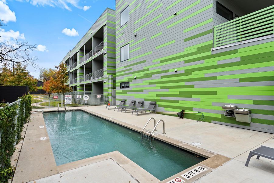 Pool with a patio area and fence