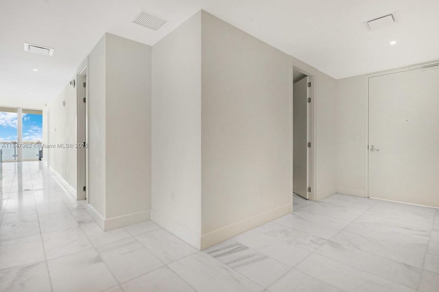 apt entrance with den and hallway towards living room area