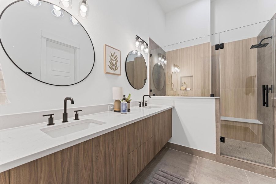 The luxurious primary ensuite features sleek modern finishes, a glass-enclosed shower with stylish tile, and a double-sink vanity topped with quartz countertops, complemented by two contemporary mirrors and lighting fixtures, creating a bright, elegant, and functional retreat. The luxurious primary ensuite features sleek modern finishes, a glass-enclosed shower with stylish tile, and a double-sink vanity topped with quartz countertops, complemented by two contemporary mirrors and lighting fixtures, creating a bright, elegant, and functional retreat.