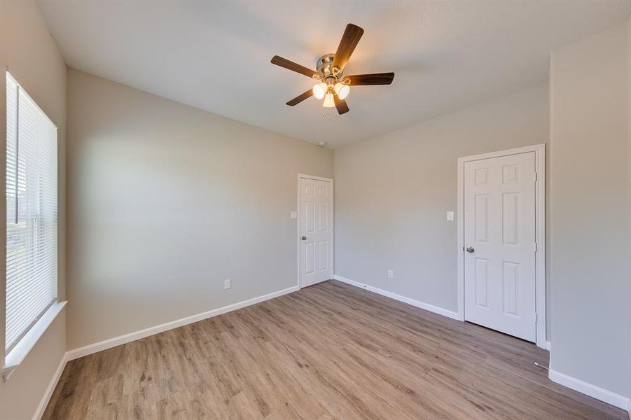 This secondary bedroom is spacious and versatile, making it ideal for guests, children, or a home office. With ample natural light streaming through the window, the room feels bright and welcoming. There's plenty of space for a bed and additional furniture, allowing for personalization to fit your style.