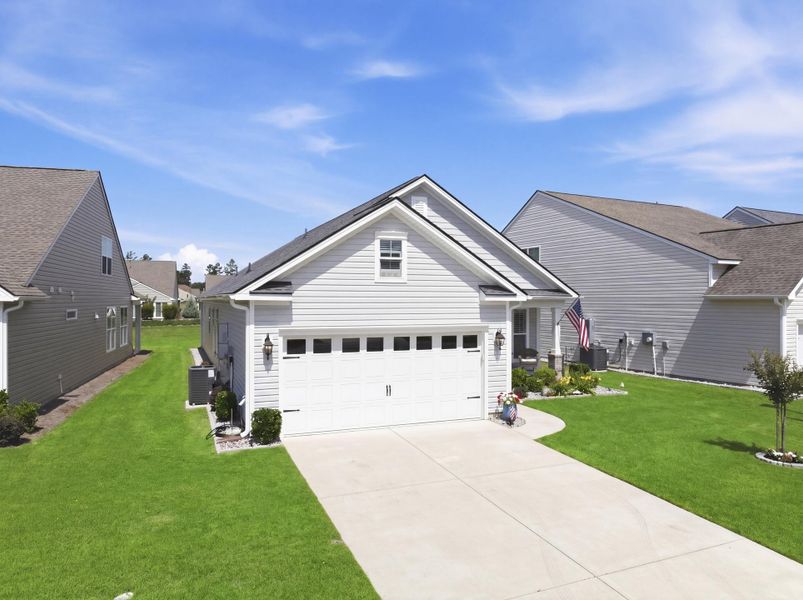 Front exterior of a new home in K. Hovnanian's® Four Seasons at Lakes of Cane Bay, Summerville, SC, highlighting curb appeal (Image 21).