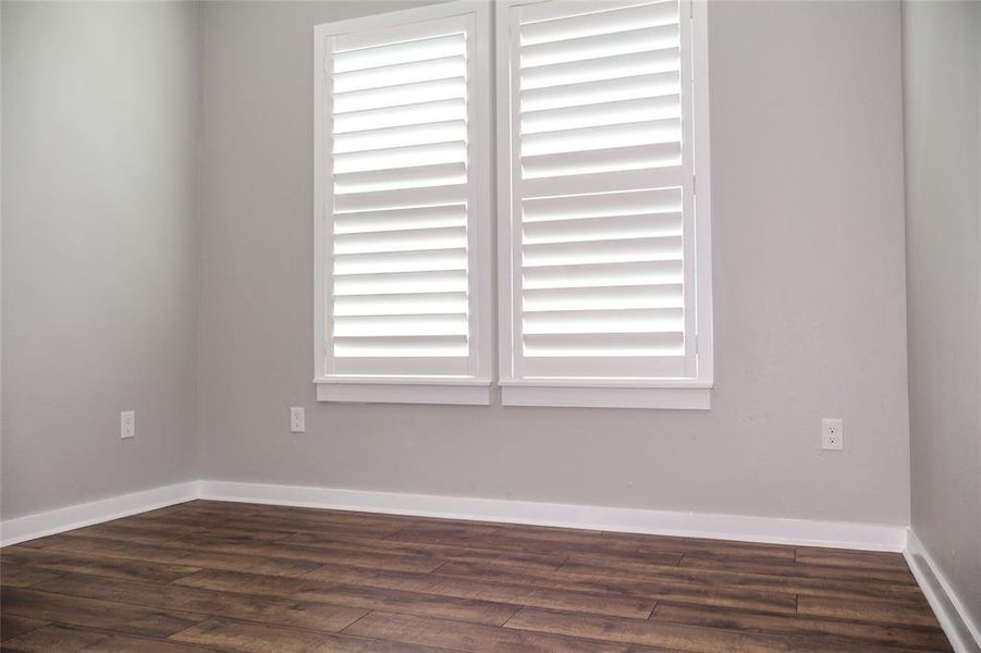 Unfurnished room featuring dark wood finished floors and plenty of natural light Unfurnished room featuring dark wood finished floors and plenty of natural light