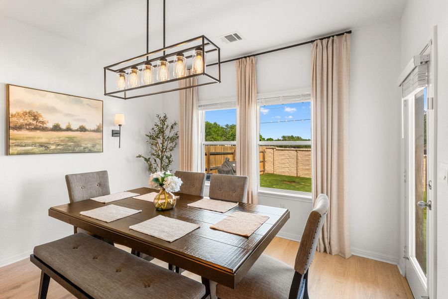 Illuminated by a contemporary chandelier, this dining area opens to a private yard through large windows. Illuminated by a contemporary chandelier, this dining area opens to a private yard through large windows.