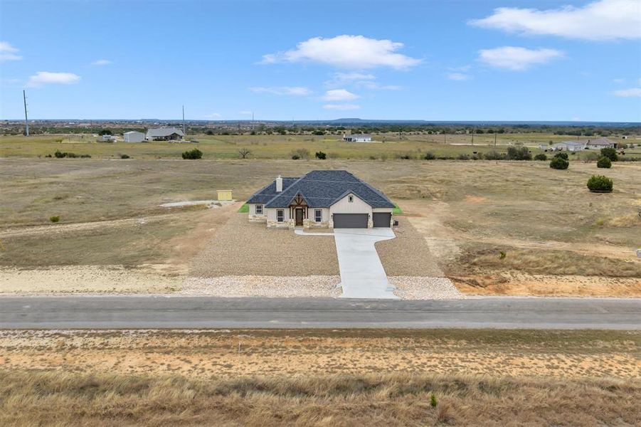 An aerial perspective showcases a custom-built home situated on an expansive rural lot. An aerial perspective showcases a custom-built home situated on an expansive rural lot.