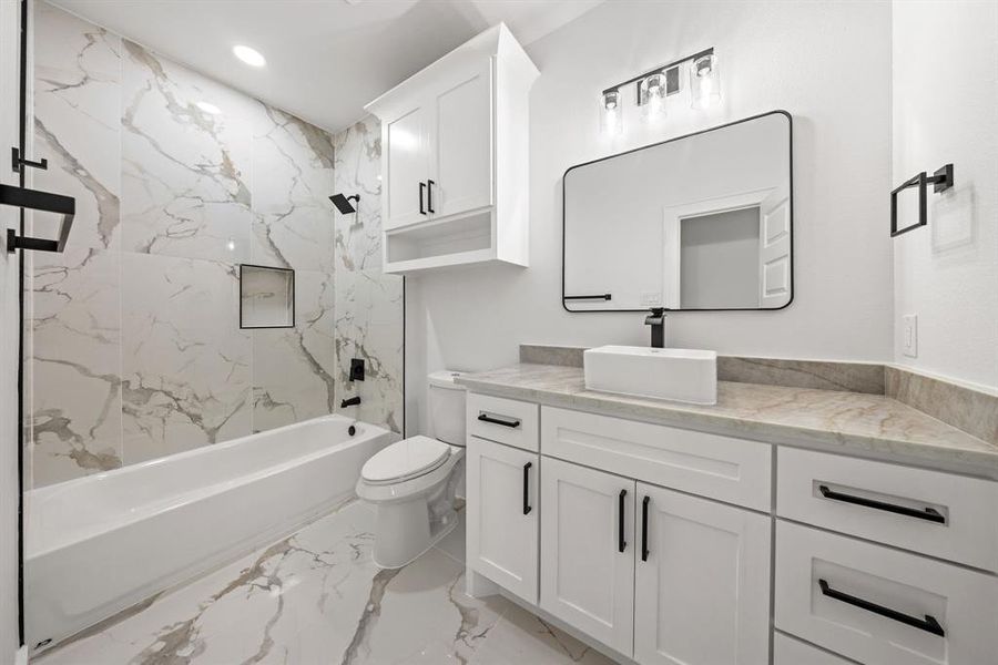 Bathroom featuring a large vanity with a rectangular vessel sink, white shaker-style cabinetry, and a light-colored countertop