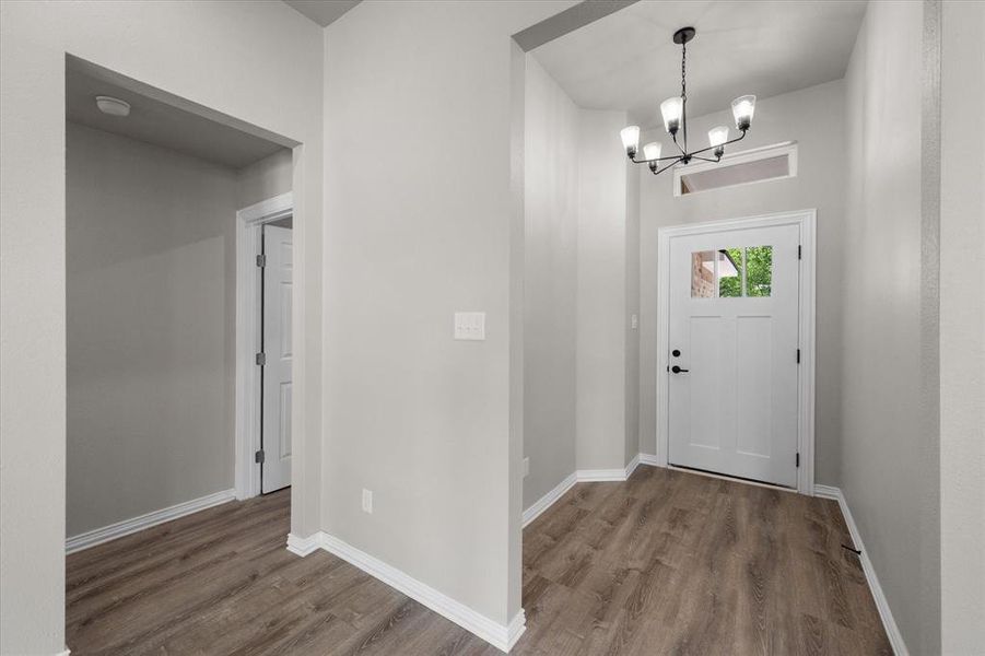 Entryway featuring wood-finish flooring, white baseboards, and light gray wall tones