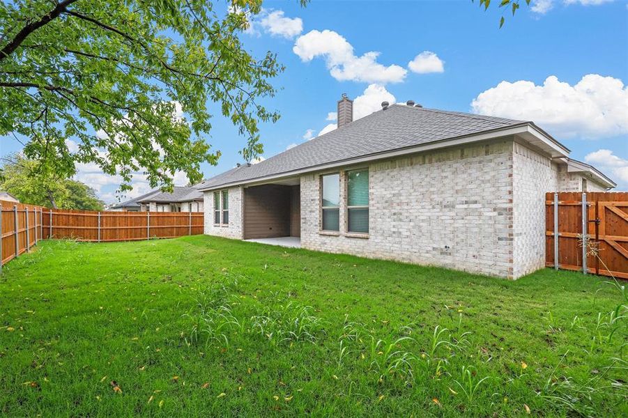 Rear view of property with a patio area and a yard