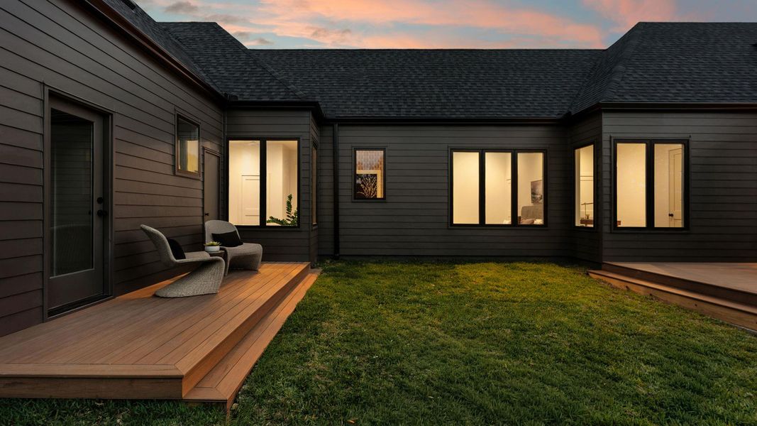 A private outdoor deck extends from the modern-styled home to a verdant yard. A private outdoor deck extends from the modern-styled home to a verdant yard.