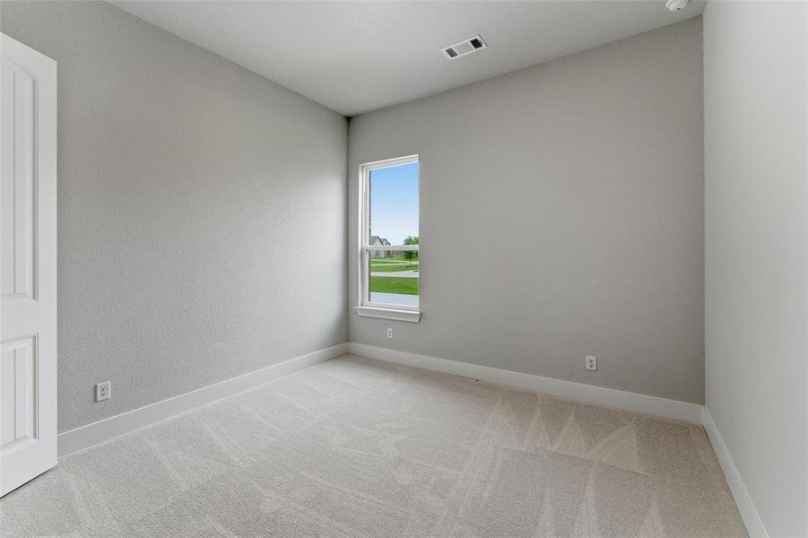 Carpeted room featuring a single window and a white paneled door