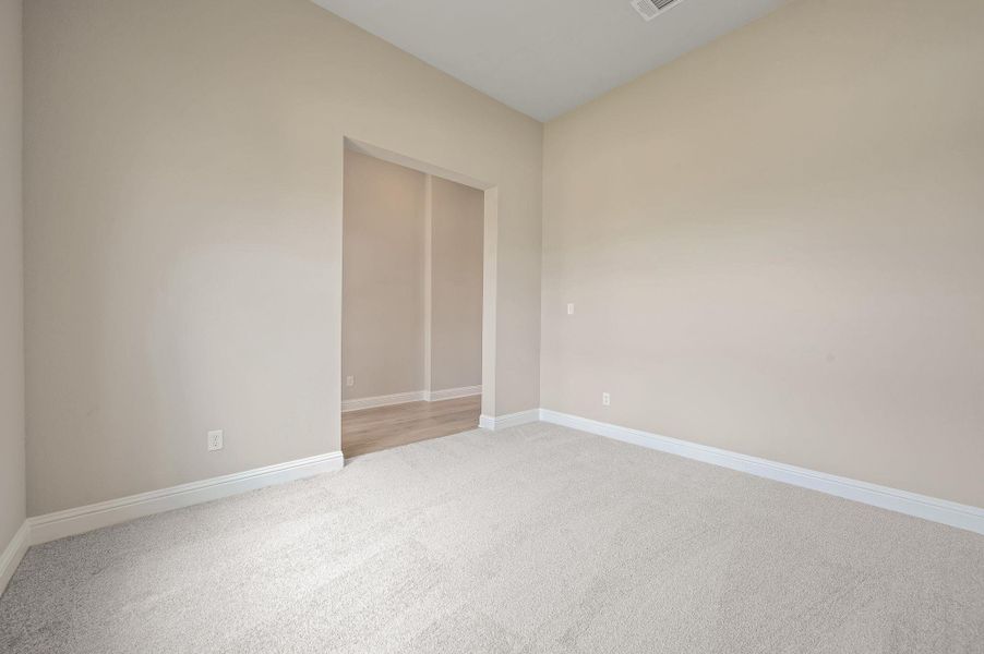Empty room with light carpet and baseboards