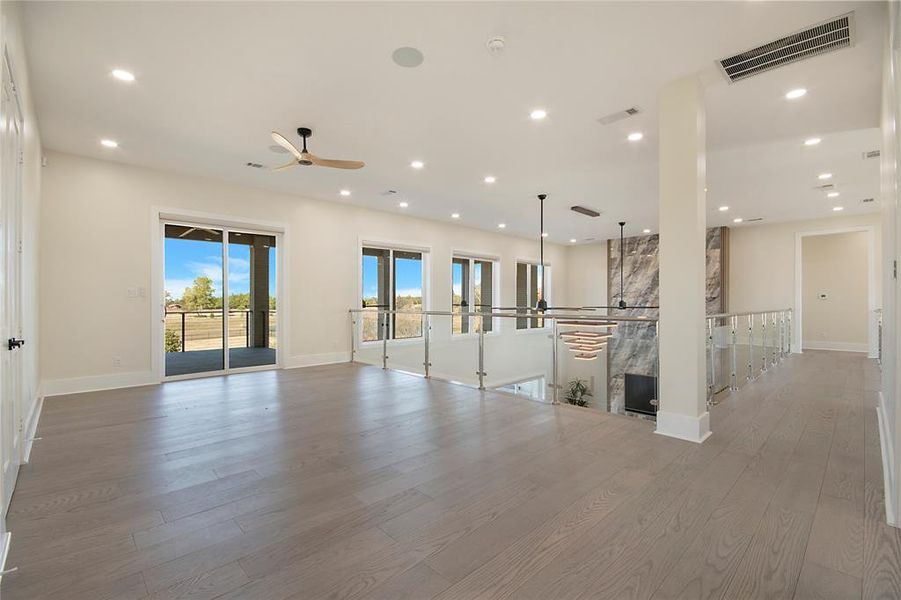 Unfurnished living room with a ceiling fan, light wood-type flooring, recessed lighting, and a fireplace Unfurnished living room with a ceiling fan, light wood-type flooring, recessed lighting, and a fireplace