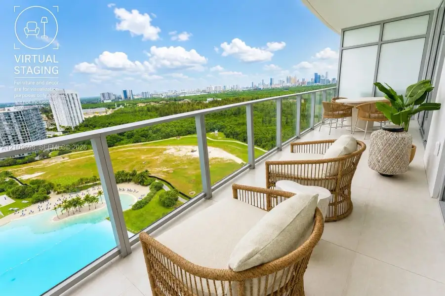 Private covered balcony featuring large-format tile flooring and a glass-paneled railing overlooking an expansive landscape and skyline