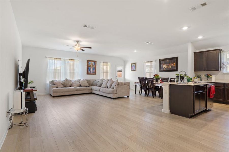 Living area featuring plenty of natural light, ceiling fan, light wood-style floors, and recessed lighting