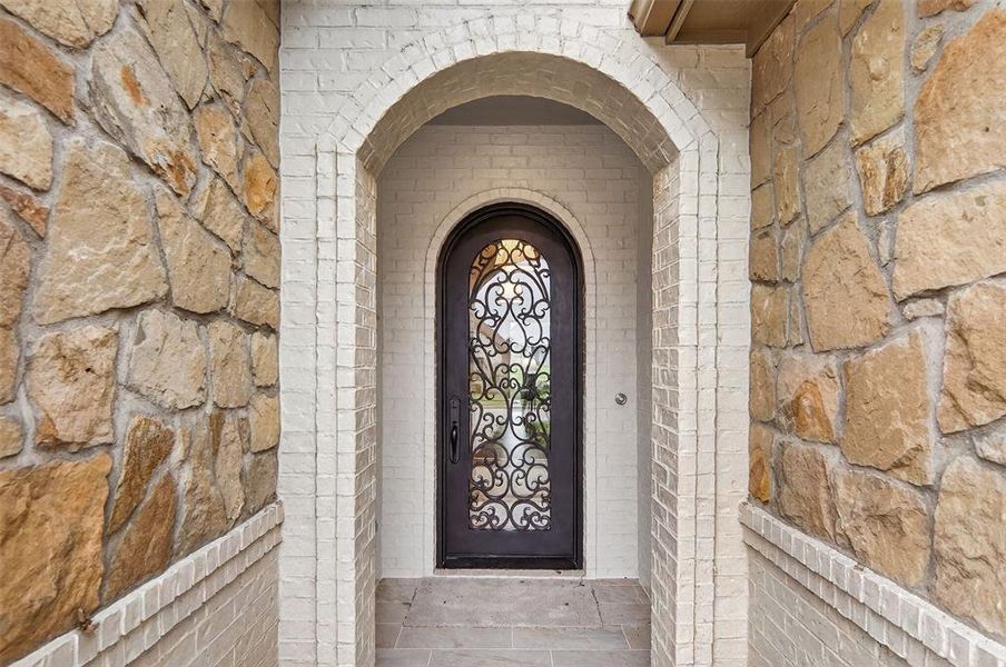 View of exterior entry featuring brick siding and stone siding