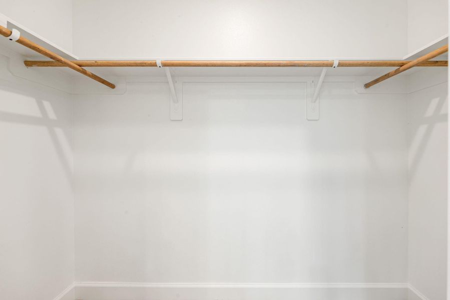 Spacious closet featuring double hanging rods and open shelving, offering plenty of storage space and easy organization. Clean, functional, and well-designed for everyday use.