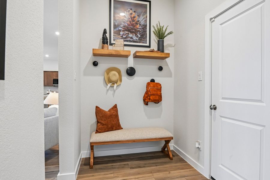 A white room with a shelf and a white door.