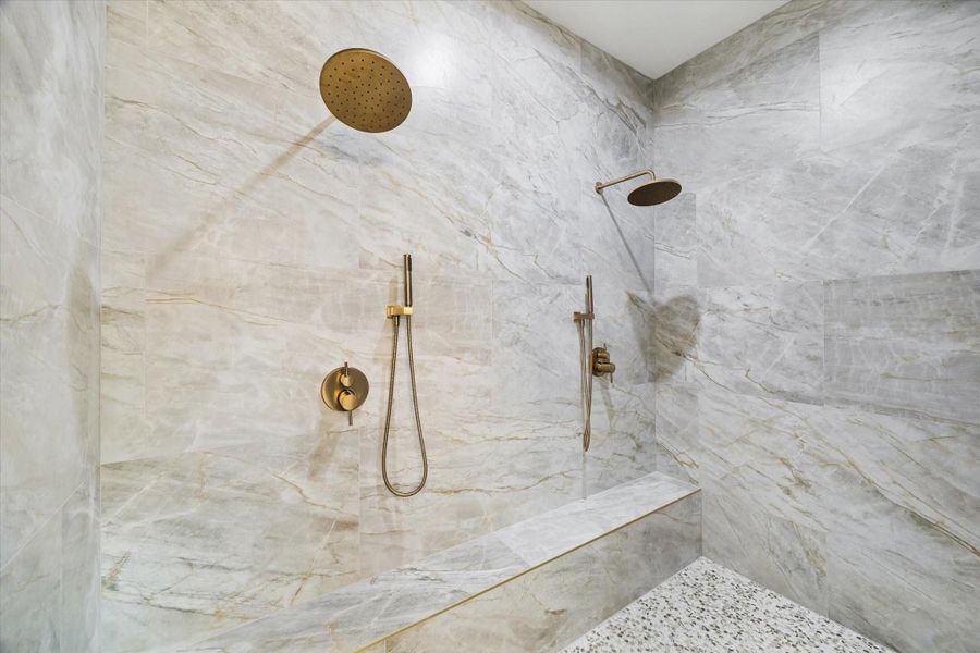 See the plan: The immense spa shower with dual installations is a memory point. The bench runs the entire length. Pebble tile flooring.
