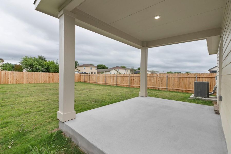 This property features a covered patio with a concrete floor, a spacious fenced yard, and a well-maintained lawn