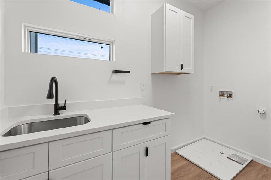 Laundry room featuring hookup for a washing machine, light wood-style flooring, and cabinet space