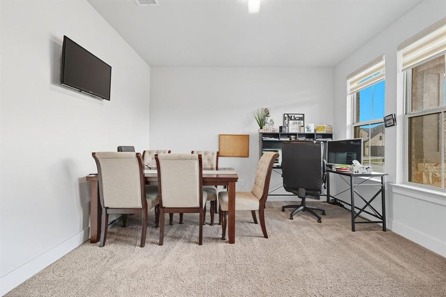 Home office featuring light colored carpet and a desk Home office featuring light colored carpet and a desk