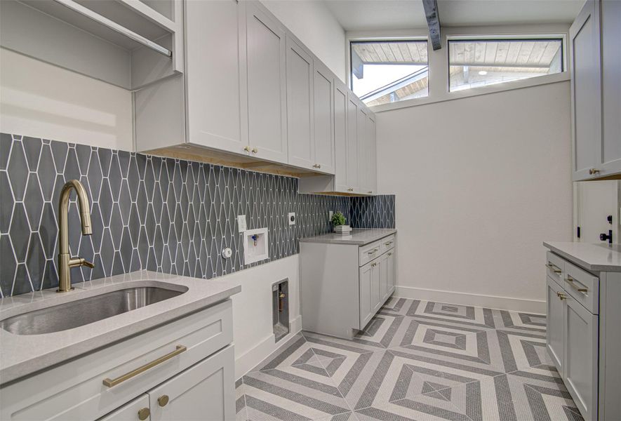 Laundry room with cabinet space, plenty of natural light, and baseboards Laundry room with cabinet space, plenty of natural light, and baseboards