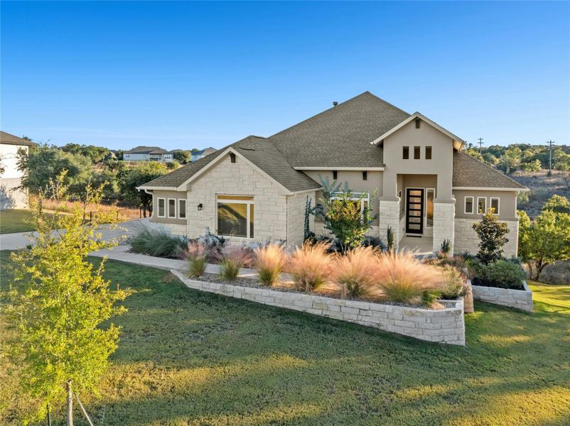 View of front of property with stone siding, a front lawn, a shingled roof, and stucco siding View of front of property with stone siding, a front lawn, a shingled roof, and stucco siding