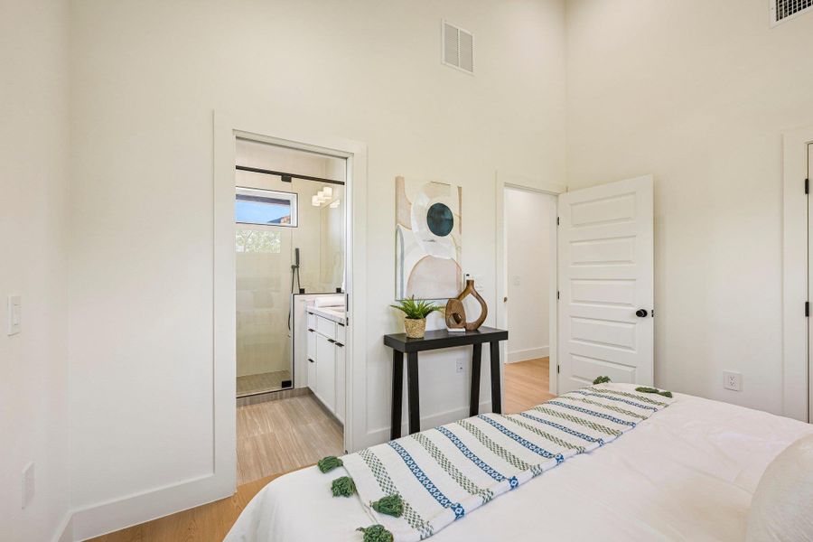 Well-lit bedroom with rich flooring and a functional en-suite bathroom. Well-lit bedroom with rich flooring and a functional en-suite bathroom.