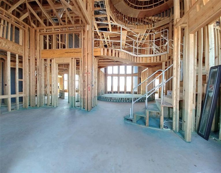 Grand Foyer view entering through the gorgeous double iron front doors with sites into the Formal Dining Room, elevated two-story Living area, winding staircase and curved catwalk with lots of design appeal is in progress.