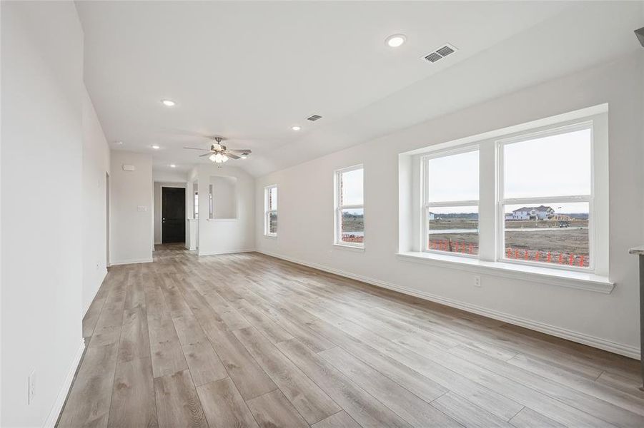 Unfurnished living room with light wood finished floors, recessed lighting, plenty of natural light, and a ceiling fan