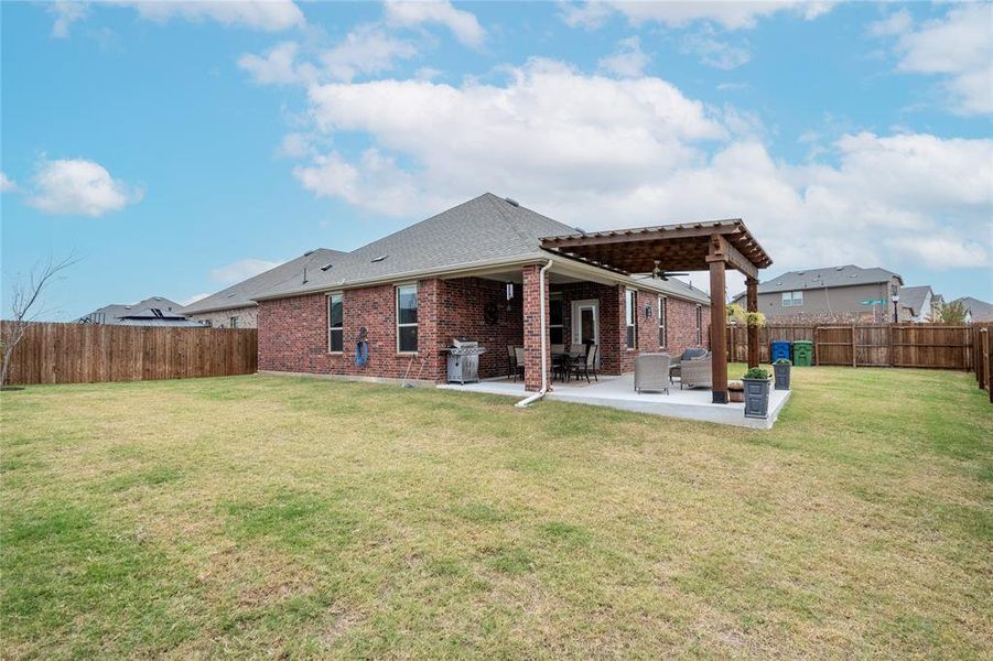 Rear view of house with a yard and a patio