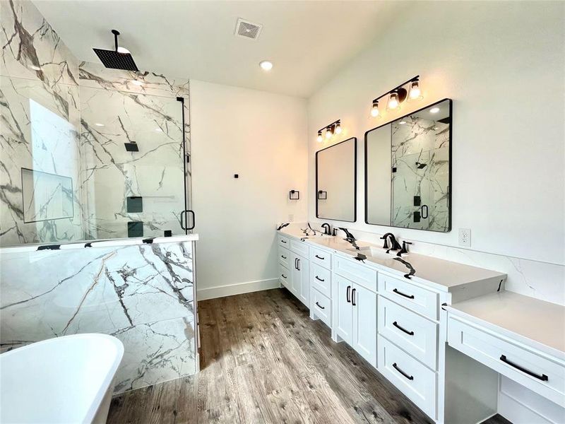 Full bathroom with double vanity, wood finished floors, visible vents, and a marble finish shower Full bathroom with double vanity, wood finished floors, visible vents, and a marble finish shower