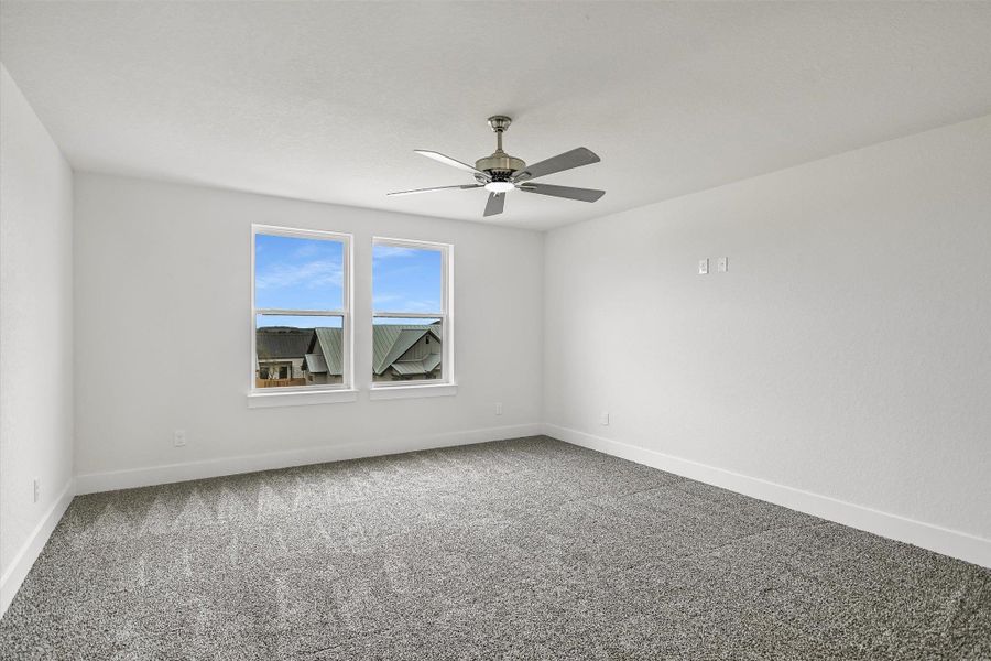 Empty room with carpet floors and a ceiling fan