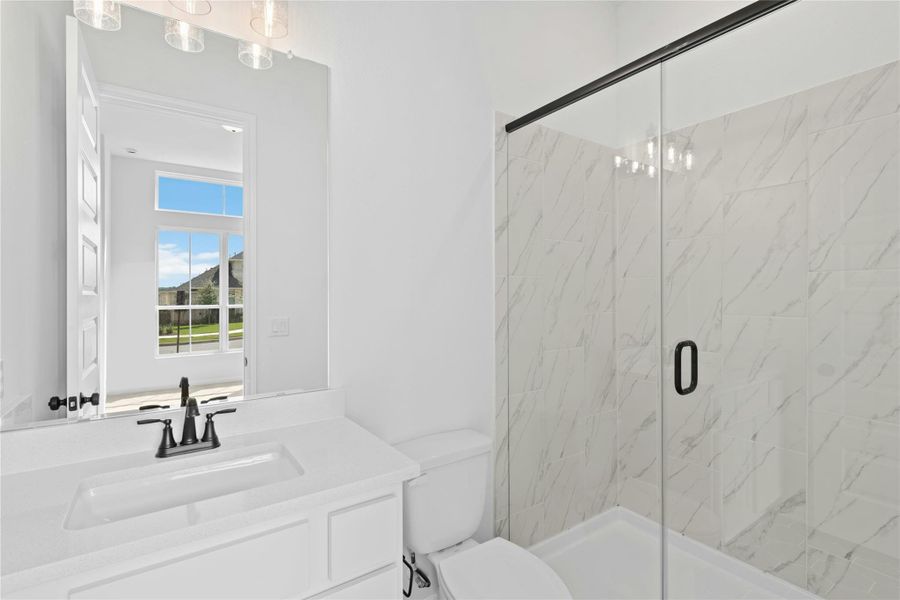 Bathroom with a marble finish shower, vanity, and a chandelier Bathroom with a marble finish shower, vanity, and a chandelier