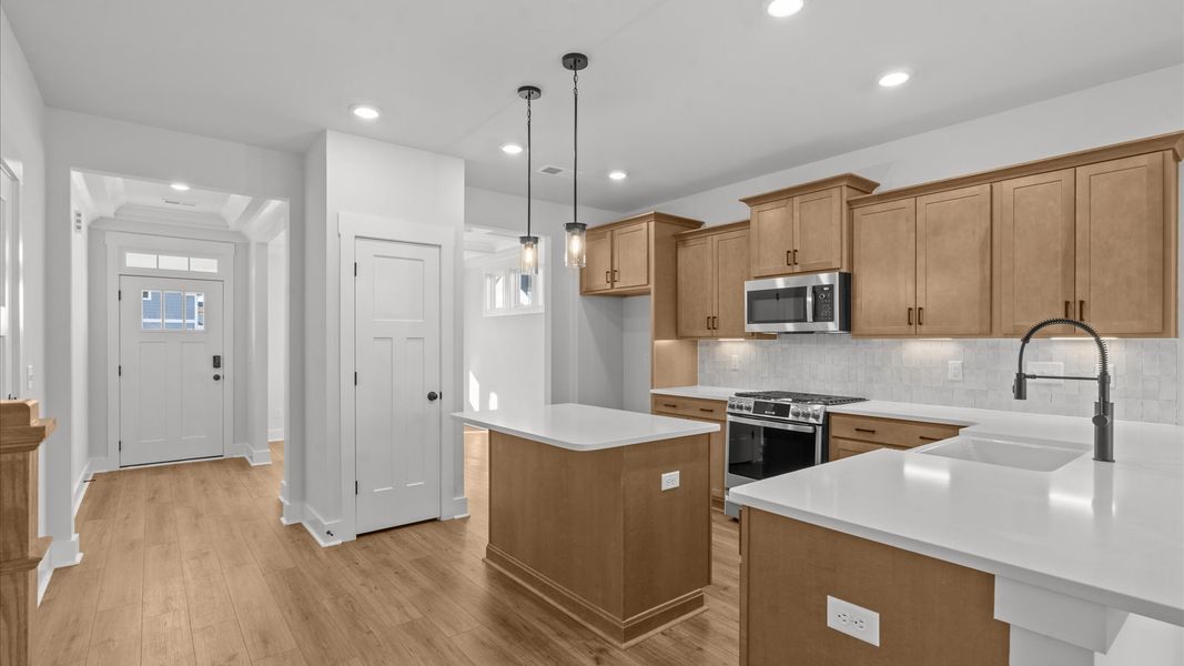 Superior kitchen with quartz countertops, pendant lighting, and a generously sized island Superior kitchen with quartz countertops, pendant lighting, and a generously sized island