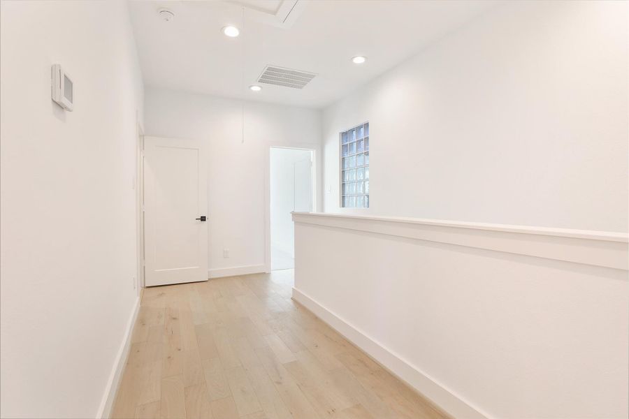 The hallway leads to a laundry room adorned with striking mosaic tile accents, adding a stylish and sophisticated touch. Located on the third floor.