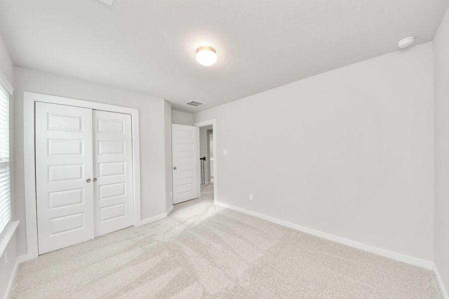 Generously sized secondary bedrooms featuring spacious closets, soft and inviting carpeting underfoot, large windows allowing plenty of natural light, and the added touch of privacy blinds for your personal retreat. Sample photo of completed home with similar floor plan. Actual colors and selections may vary. Generously sized secondary bedrooms featuring spacious closets, soft and inviting carpeting underfoot, large windows allowing plenty of natural light, and the added touch of privacy blinds for your personal retreat. Sample photo of completed home with similar floor plan. Actual colors and selections may vary.