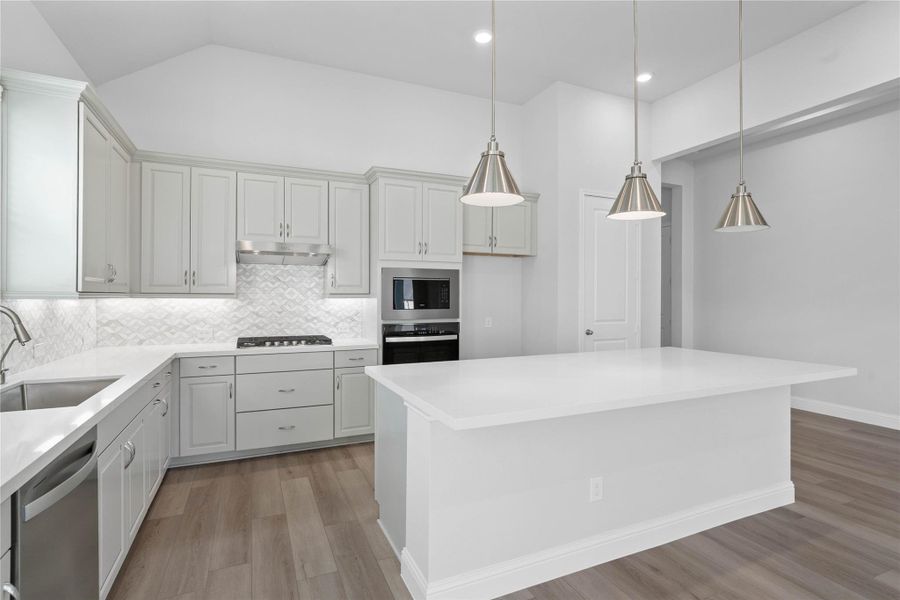 This gourmet kitchen is a true entertainer's dream, featuring sleek, modern design elements like the expansive white quartz island and complementary white cabinetry. Top-of-the-line appliances and elegant pendant lighting create a clean, bright, and inviting space perfect for both casual dining and hosting sophisticated gatherings. This gourmet kitchen is a true entertainer's dream, featuring sleek, modern design elements like the expansive white quartz island and complementary white cabinetry. Top-of-the-line appliances and elegant pendant lighting create a clean, bright, and inviting space perfect for both casual dining and hosting sophisticated gatherings.