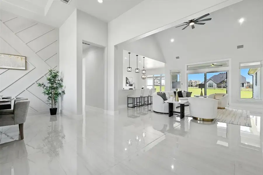Living area featuring ceiling fan, recessed lighting, and high vaulted ceiling Living area featuring ceiling fan, recessed lighting, and high vaulted ceiling