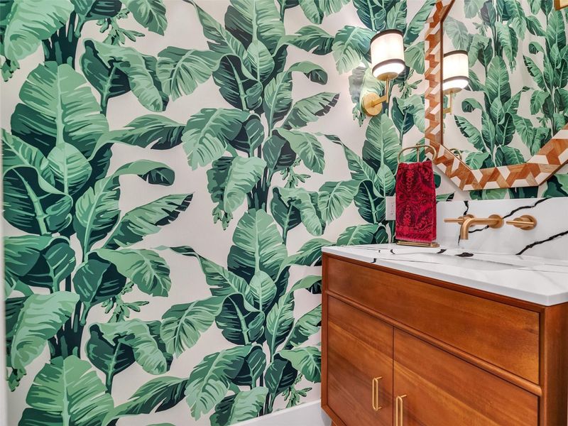 Step into this stylish powder room that perfectly captures the home’s coastal elegance. The custom green leaf wallpaper instantly sets a vibrant, beach-chic tone, while the modern sink and sleek fixtures bring a refined touch. It’s the kind of space that makes guests pause and smile — bright, bold, and full of personality. Whether you’re hosting a dinner party or simply enjoying a quiet evening in, even the smallest moments here feel a little more special, surrounded by beauty and seaside charm. Step into this stylish powder room that perfectly captures the home’s coastal elegance. The custom green leaf wallpaper instantly sets a vibrant, beach-chic tone, while the modern sink and sleek fixtures bring a refined touch. It’s the kind of space that makes guests pause and smile — bright, bold, and full of personality. Whether you’re hosting a dinner party or simply enjoying a quiet evening in, even the smallest moments here feel a little more special, surrounded by beauty and seaside charm.