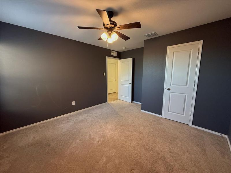 Spacious room featuring neutral carpet flooring and dark painted walls Spacious room featuring neutral carpet flooring and dark painted walls